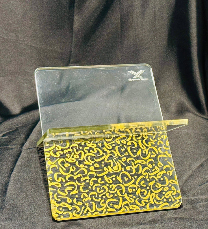 Transparent Quran stand made from 8mm acrylic with golden screen-printed Arabic design. Elegant, durable, and ideal for home, mosque, and gifts.