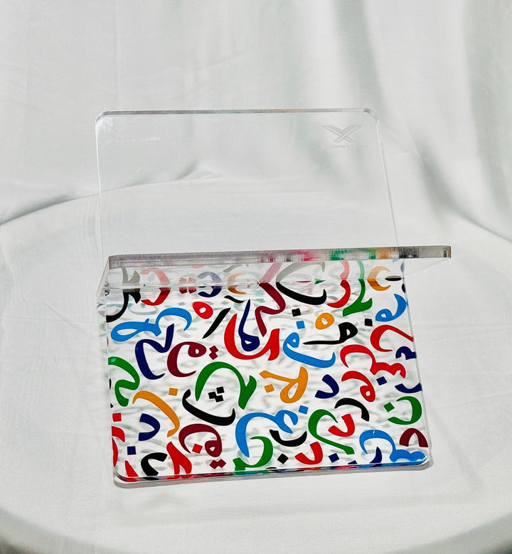 Elegant acrylic Quran stand made from 8mm acrylic with UV printed multi-color Arabic alphabets. Durable, stylish, and ideal for home, mosque, and gifting.